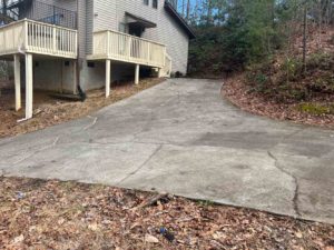 Large structural cracks in a concrete driveway with visible slab displacement and uneven surfaces, requiring a professional settlement evaluation by Sensible Concrete Works LLC in East Tennessee.